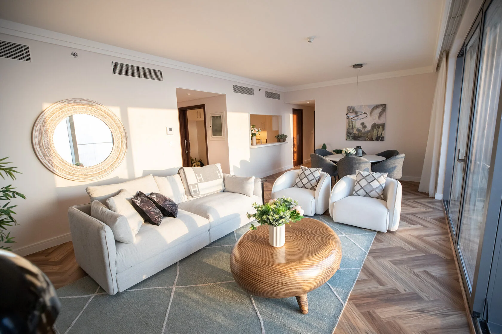 Living room with herringbone flooring, round timber coffee table and sea-facing windows