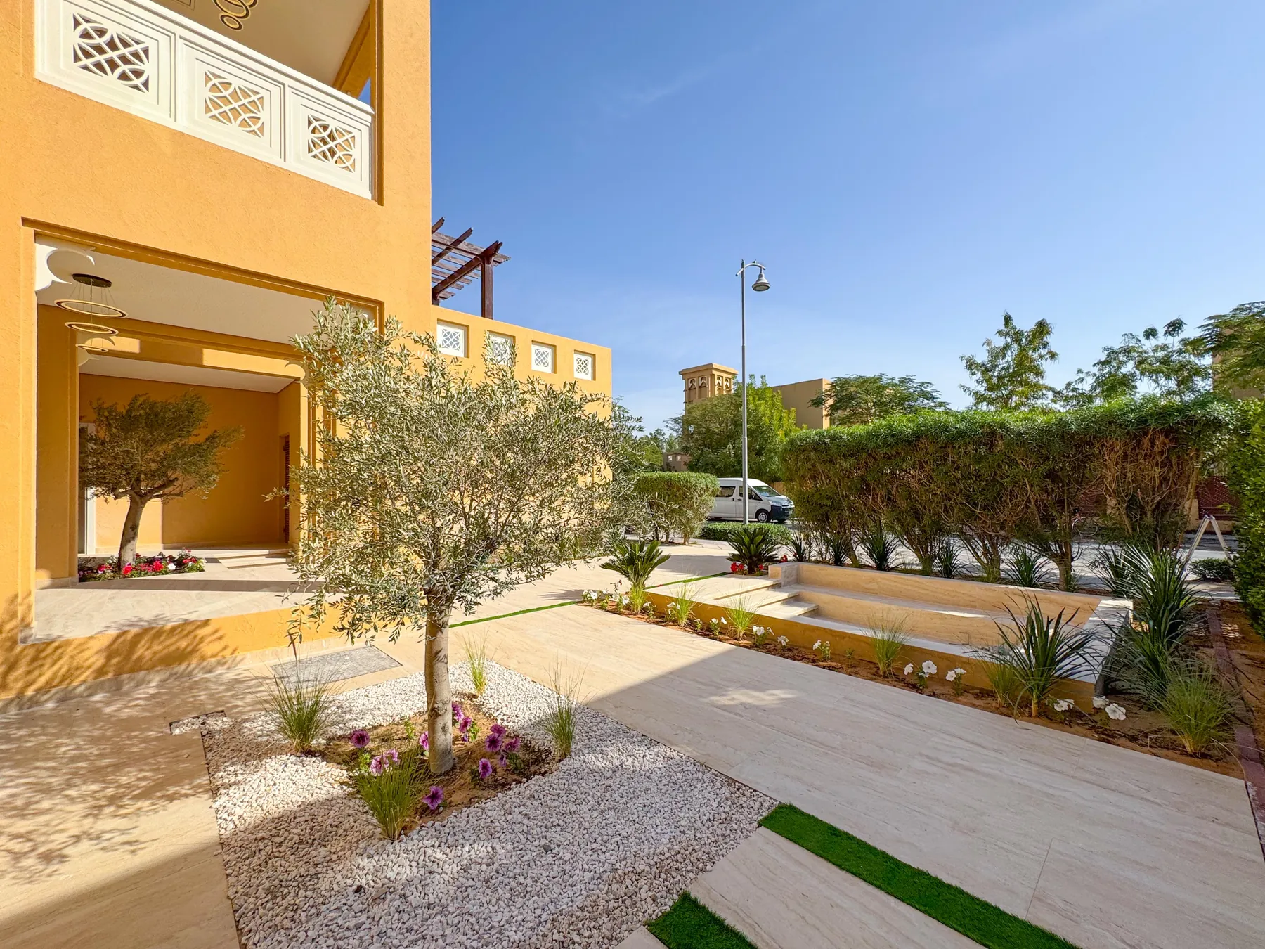 Villa garden with olive tree and sandstone paving in Dubai
