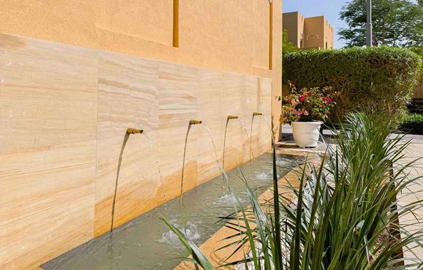 Villa courtyard with sandstone wall water feature and planting