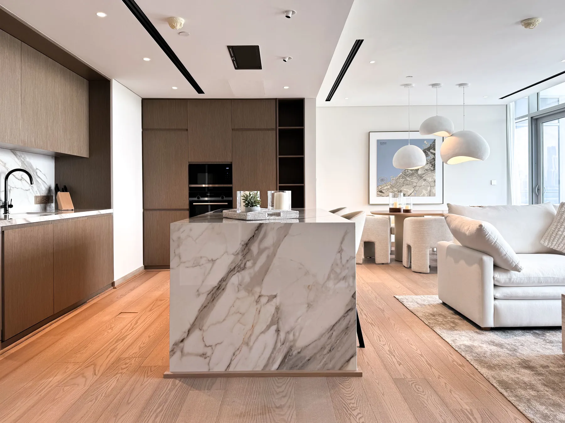 Apartment kitchen with marble-clad island opening onto the living area
