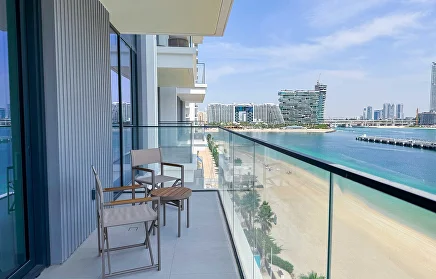 Apartment balcony with glass balustrade overlooking the beach and Dubai skyline