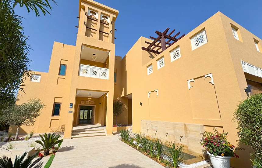 Arabian-style villa entrance with wind tower and landscaped garden in Dubai