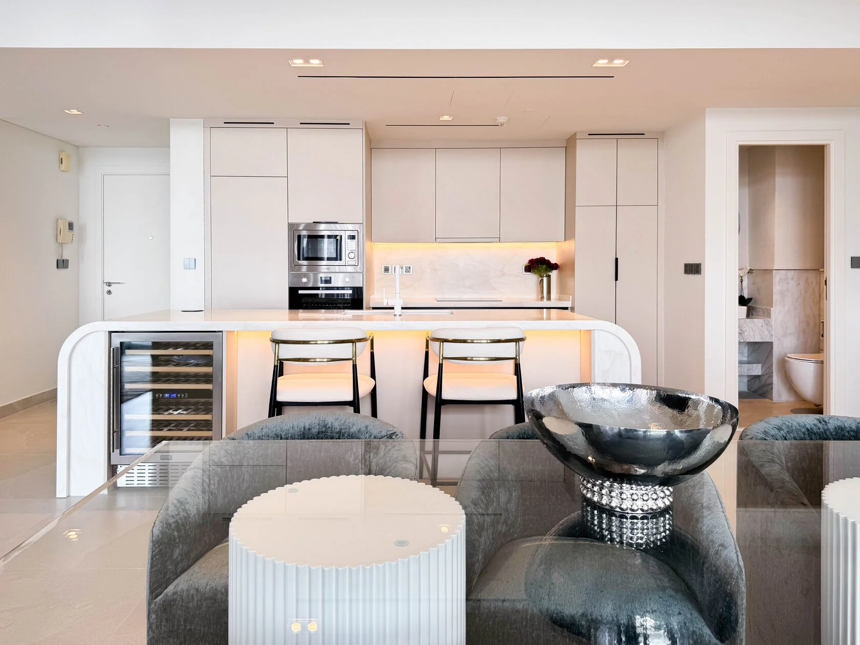 Transitional Minimalist 2-Bed Apartment – open kitchen with curved island and wine cooler
