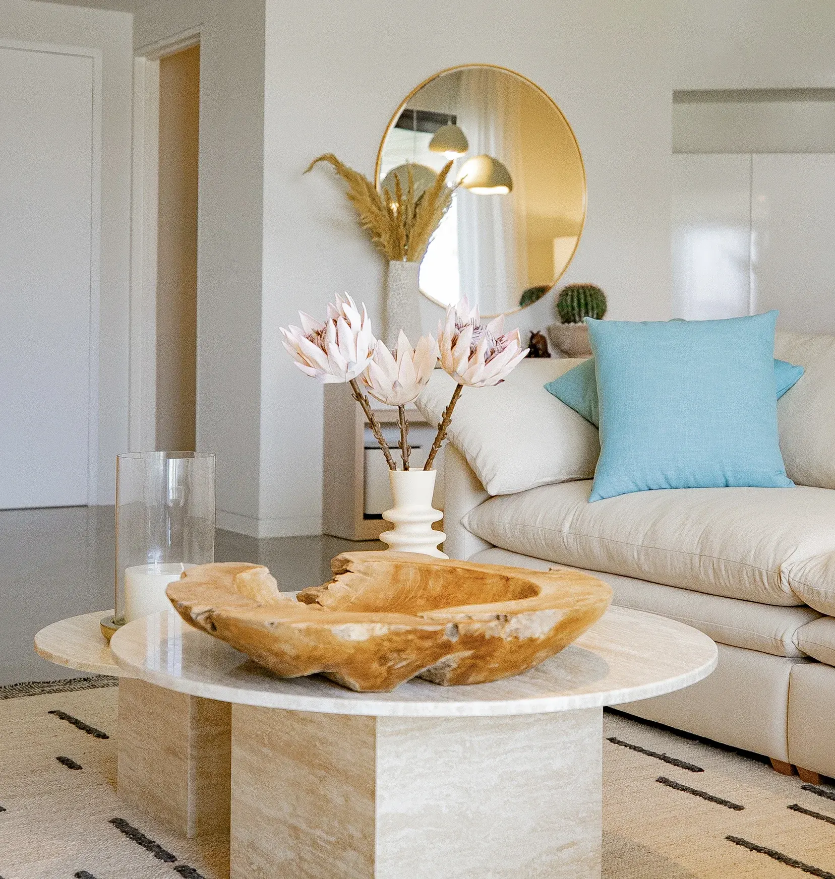Styled living room with travertine coffee table, cushions and gold accents
